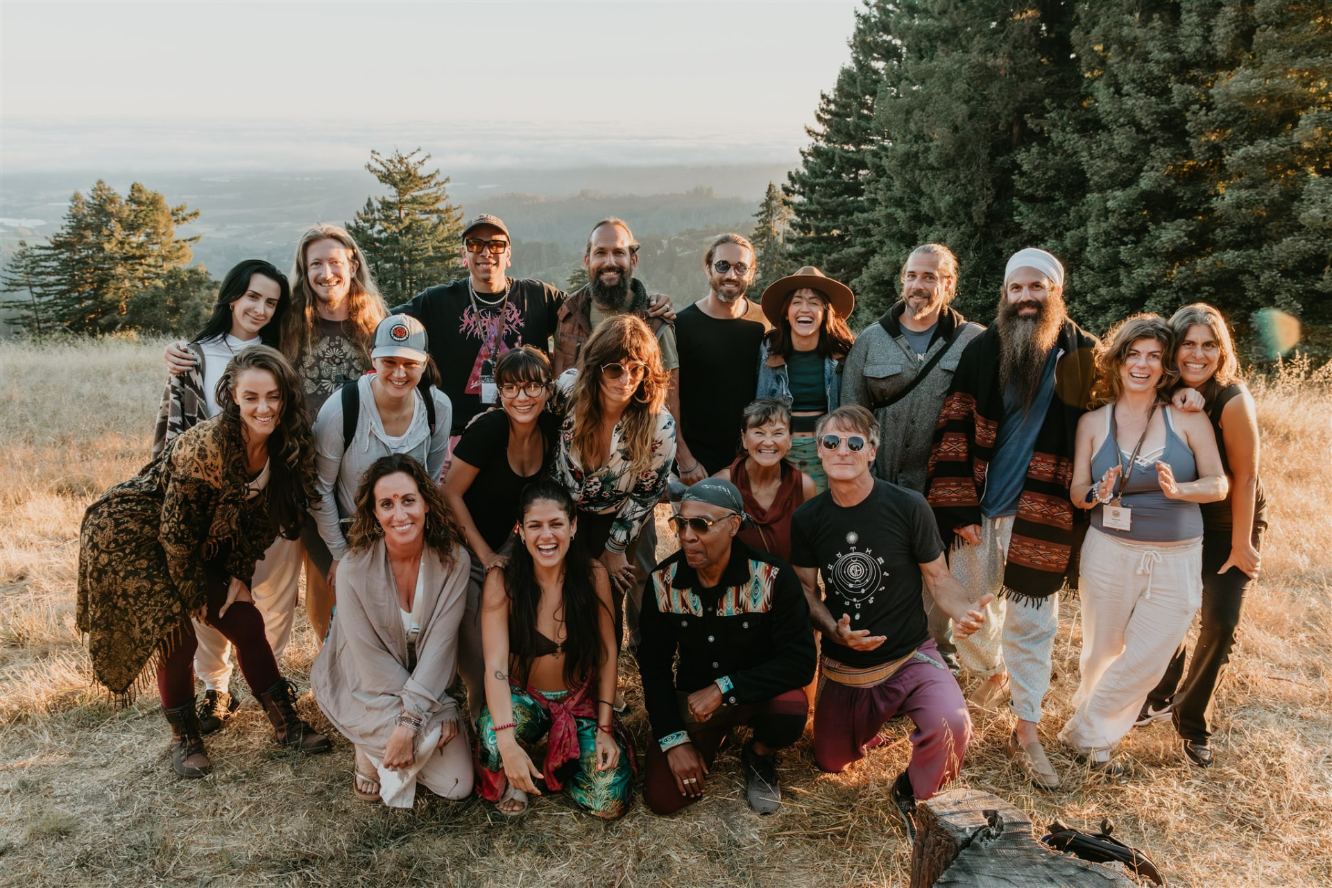 Group of retreat participants gathered on a golden hillside at sunset