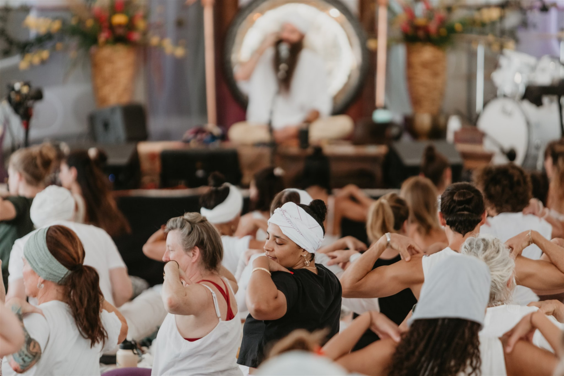 Participants stretching together as a gong is played on stage