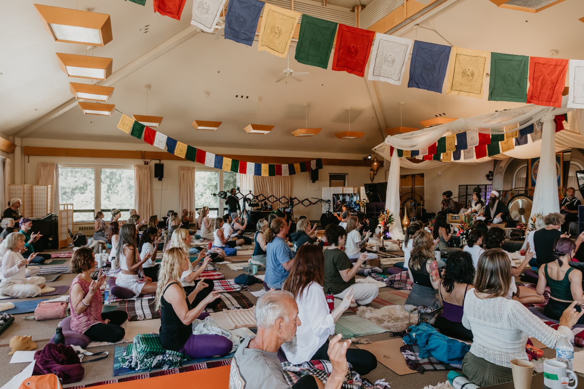 Wide view of the hall filled with practitioners and prayer flags
