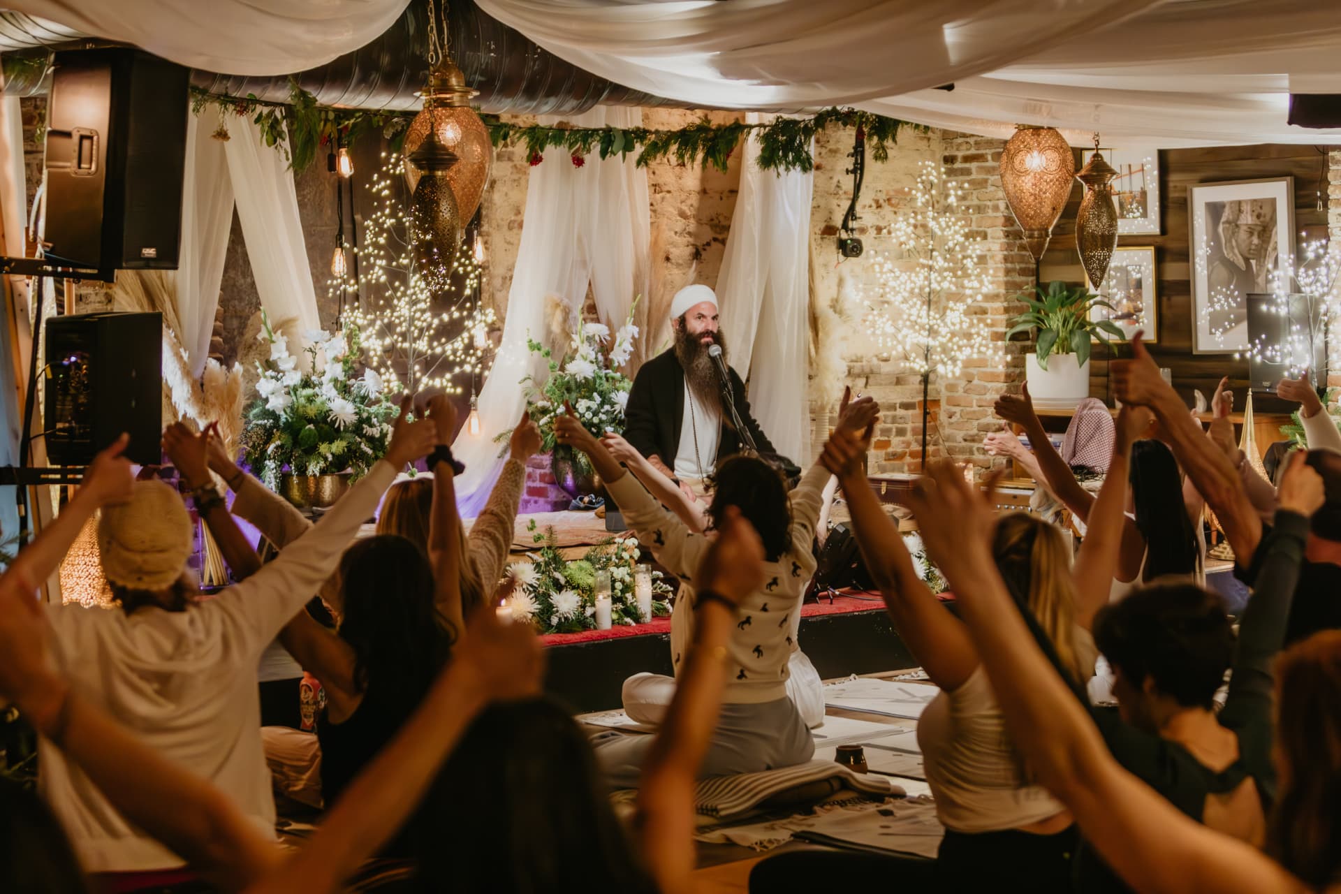 Candlelit solstice gathering with white draped fabric and brass lanterns