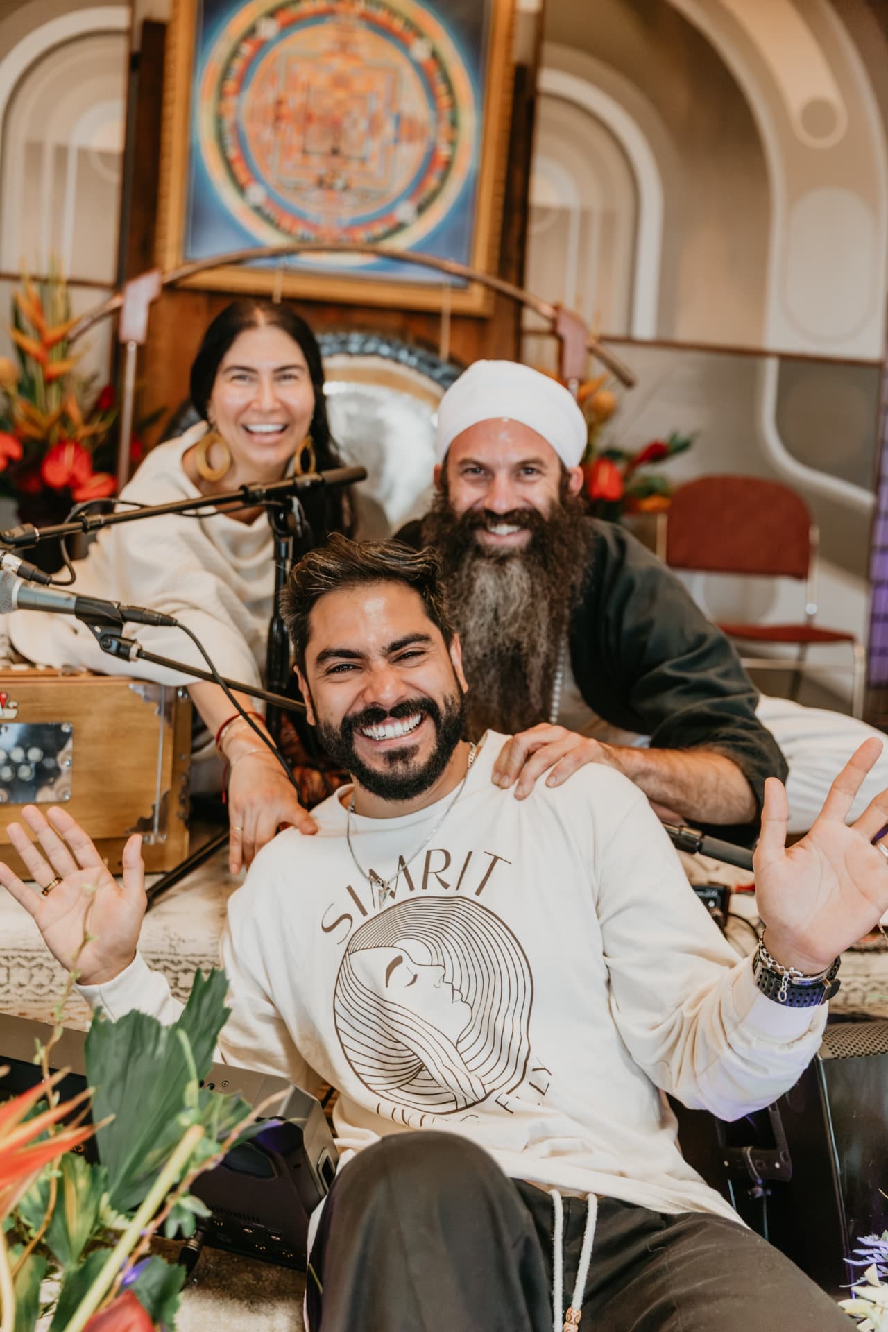 SIMRIT and musicians laughing together beside the harmonium