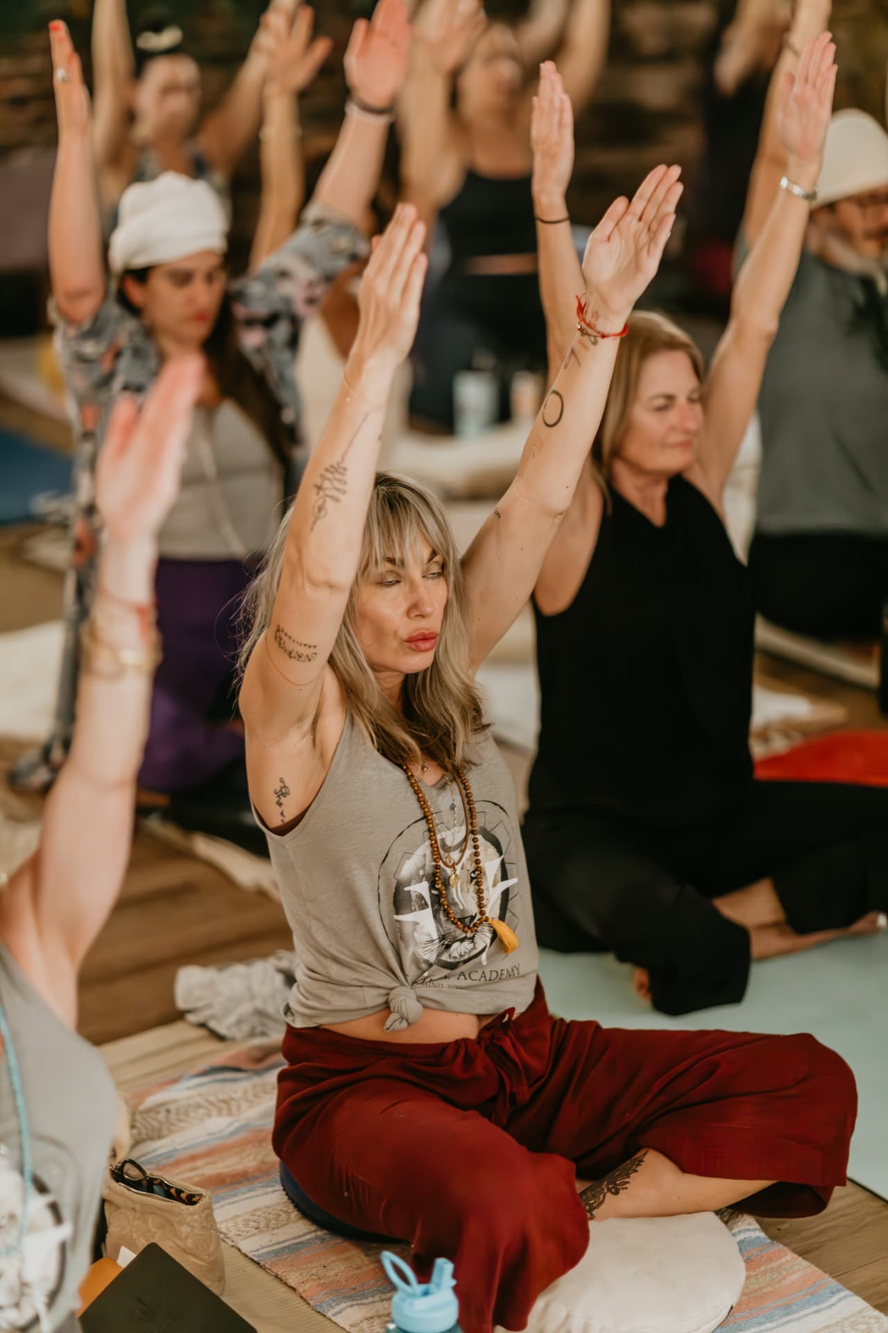 Group with arms raised overhead in kundalini practice